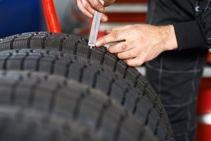 Reifen wird mit einem Profiltiefenmesser geprüft