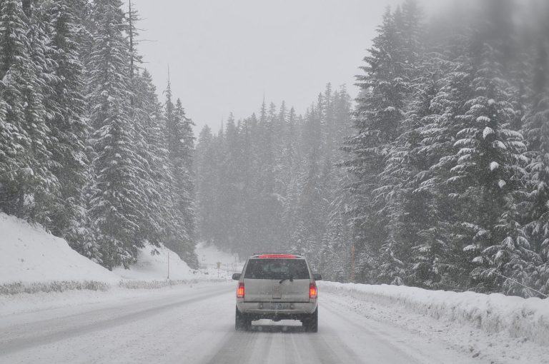 SUV auf zugeschneiter Straße unterwegs mit Winterreifen zum Sprit sparen